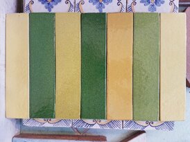 Sicilian tiles in green and yellow tones with floral patterns, handcrafted ceramics.