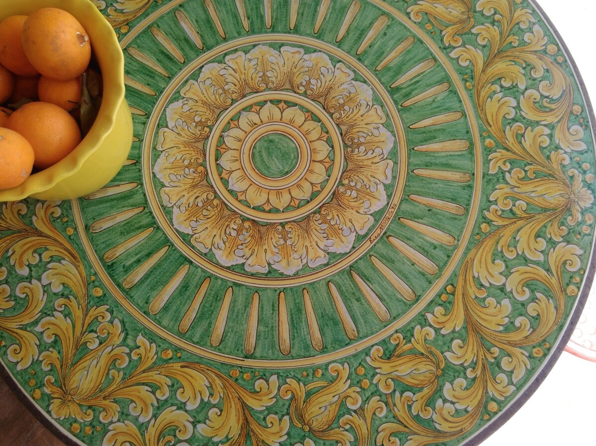 Sicilian tiles with green and yellow floral design and bowl of oranges