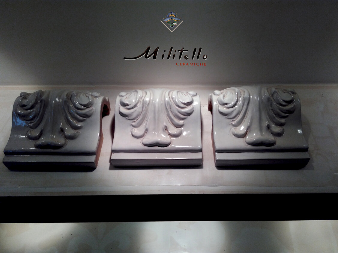 Tre decorative maioliche siciliane di pregiato design artigianale esposte su mensola