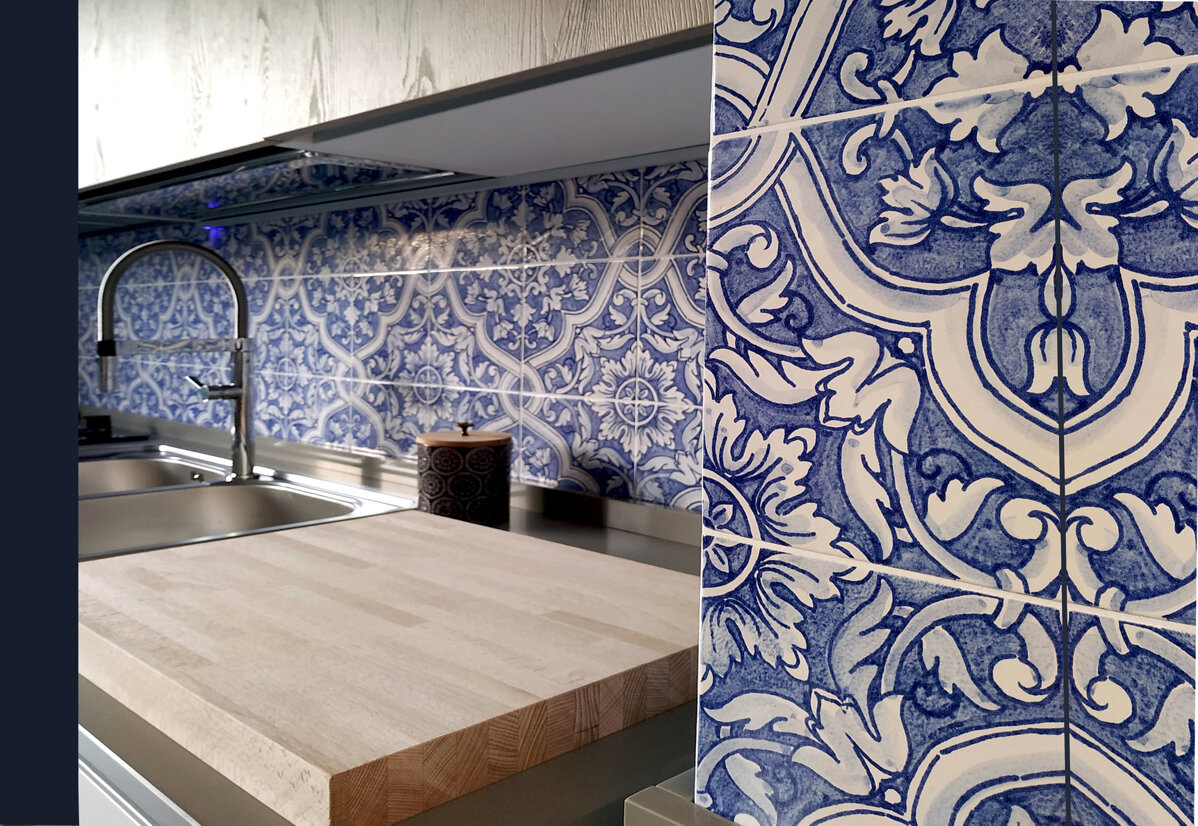 Kitchen with blue and white Sicilian tiles backsplash and wooden countertop.