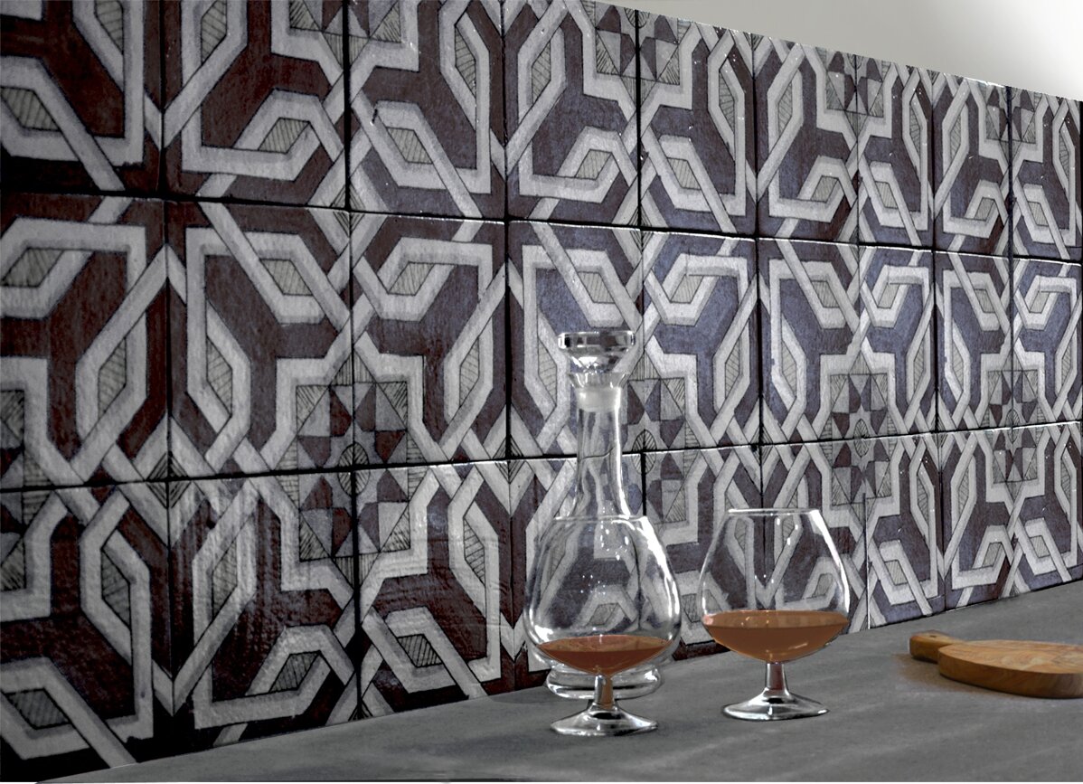 Geometric Sicilian tiles with glassware on a countertop, showcasing Mediterranean design.