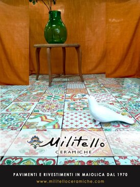 Sicilian tiles with a green glass vase and white ceramic bird