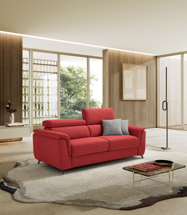 Modern red sofa bed in stylish living room with large windows and contemporary decor.
