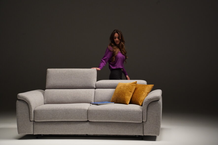 Divano moderno con cuscini gialli e donna in maglione viola