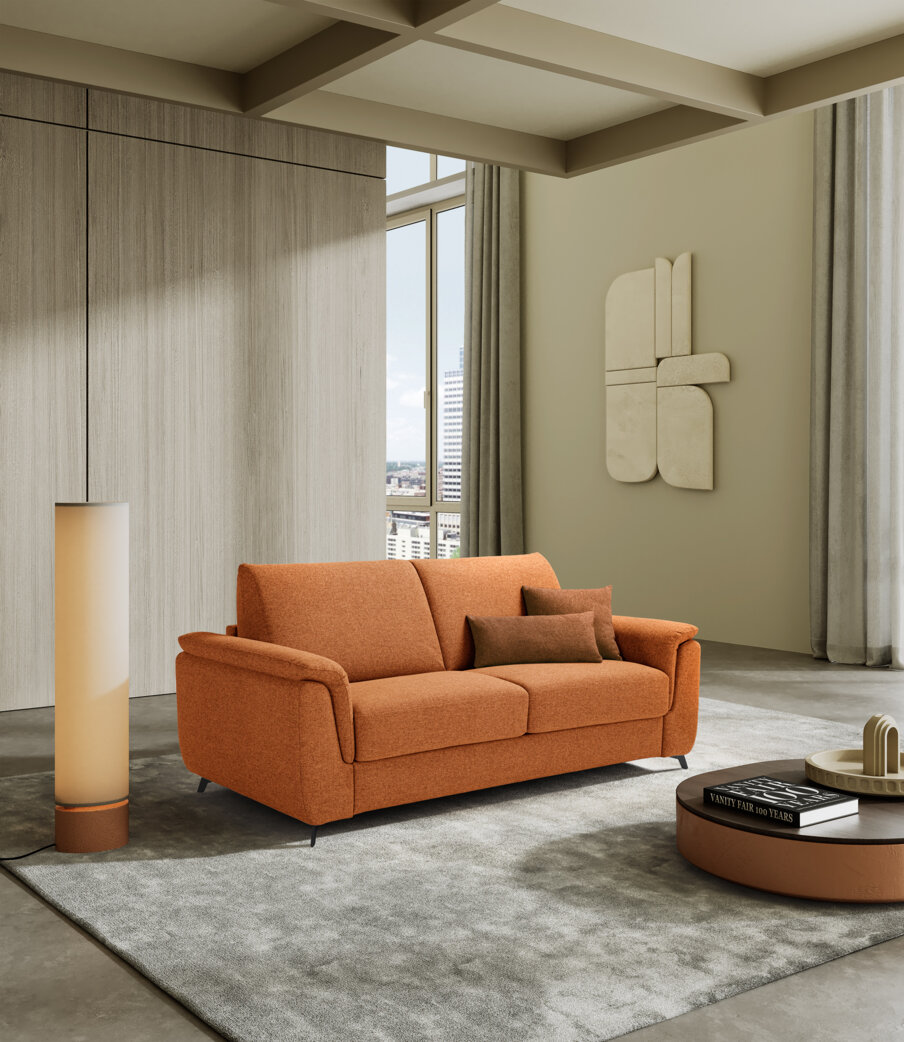 Divano letto arancione in un elegante soggiorno, espressione di artigianalità Made in Italy, comfort per la casa.
