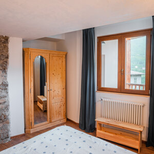 Camera da letto rustica con armadio in legno e muro in pietra Camera da letto rustica con armadio in legno e muro in pietra