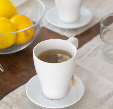 Tazza di tè su tavola con limoni e zucchero Tazza di tè su tavola con limoni e zucchero
