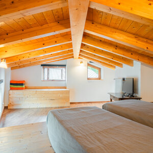 Sottotetto in legno con due letti singoli e spazio luminoso Sottotetto in legno con due letti singoli e spazio luminoso