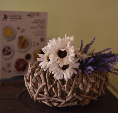 Composizione floreale con margherite e lavanda in un vaso di rami intrecciati, con menu sullo sfondo Composizione floreale con margherite e lavanda in un vaso di rami intrecciati, con menu sullo sfondo