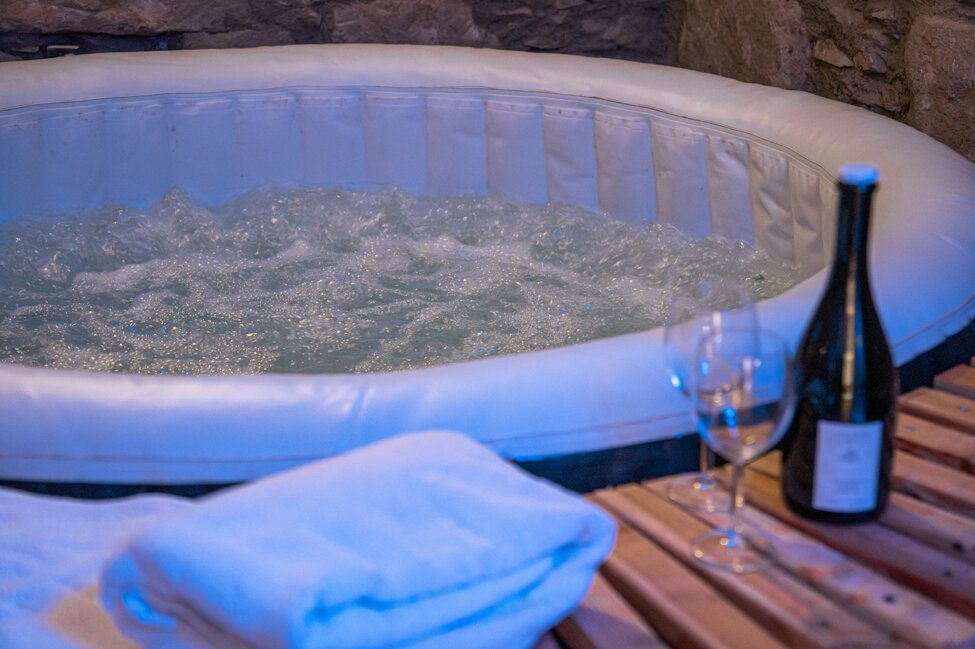 Vasca idromassaggio con asciugamani e bottiglia di vino