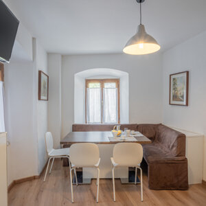 Sala da pranzo accogliente con tavolo, sedie, divano e televisore. Sala da pranzo accogliente con tavolo, sedie, divano e televisore.