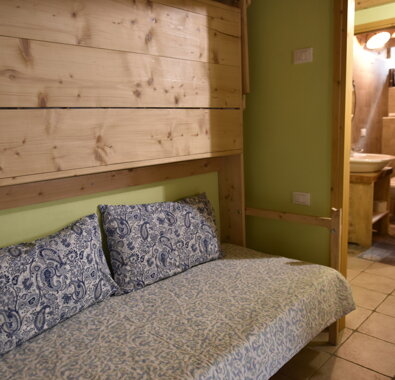 Camera con letto singolo e bagno adiacente, arredamento in legno chiaro. Camera con letto singolo e bagno adiacente, arredamento in legno chiaro.