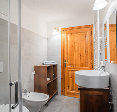 Bagno moderno con lavabo, bidet e arredi in legno in un appartamento La Torre Bagno moderno con lavabo, bidet e arredi in legno in un appartamento La Torre