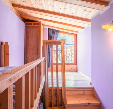 Interno di un appartamento lilla con balcone in legno, luce comfortevole.