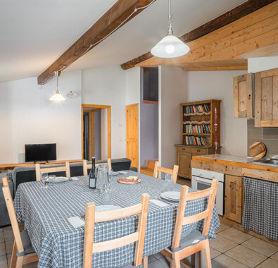 Interno di appartamento rustico con cucina e tavolo da pranzo