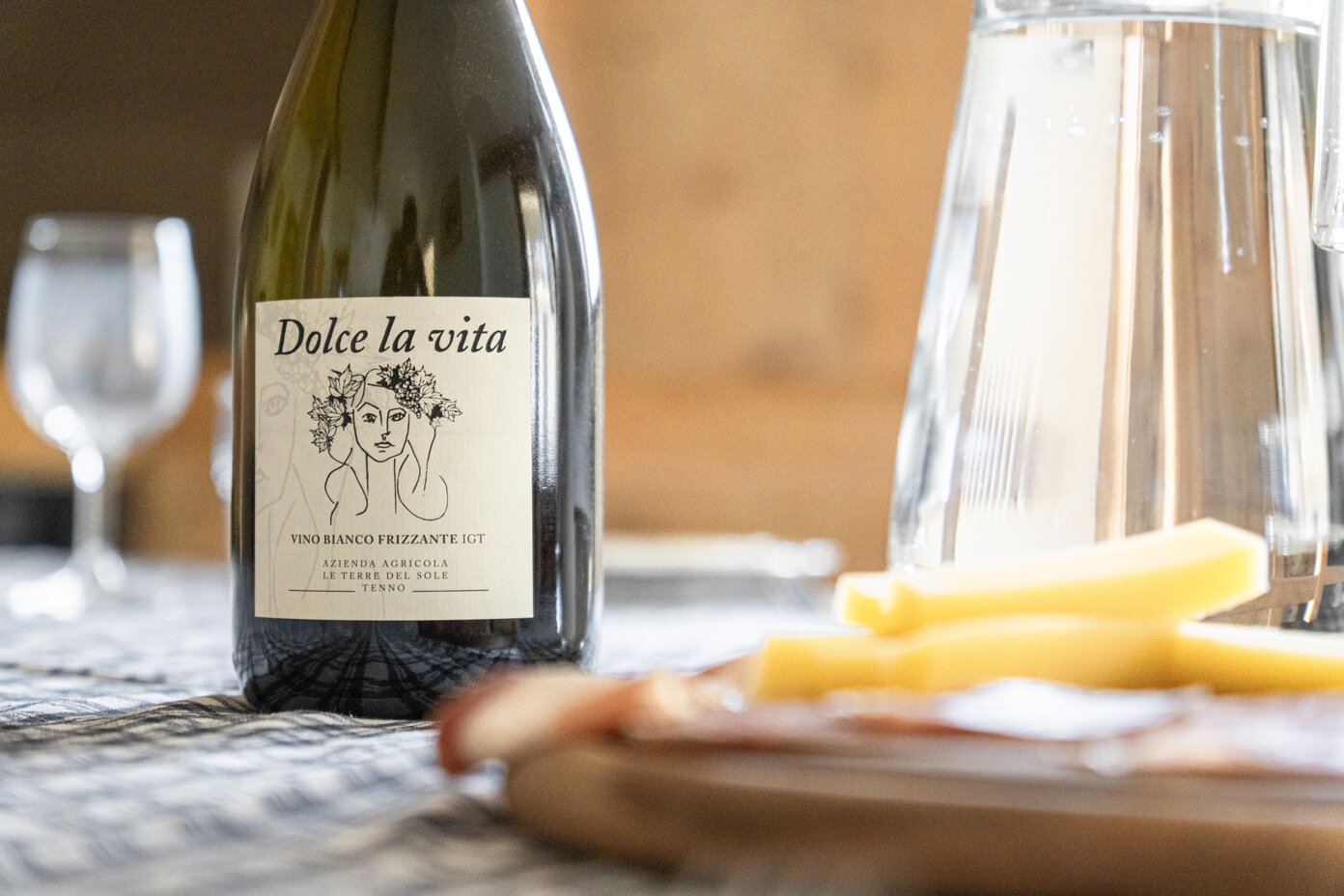 Bottiglia di vino bianco frizzante Tenno su tavola imbandita