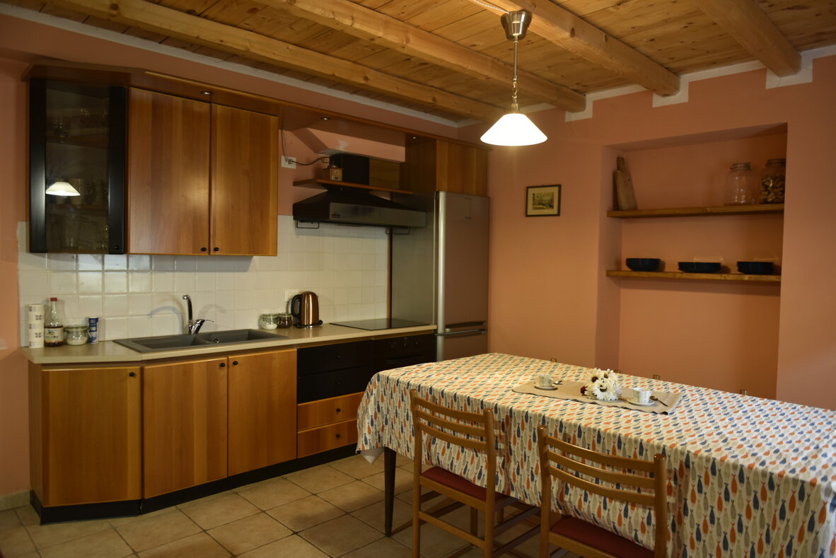 Cucina accogliente in legno con tavolo apparecchiato Cucina accogliente in legno con tavolo apparecchiato