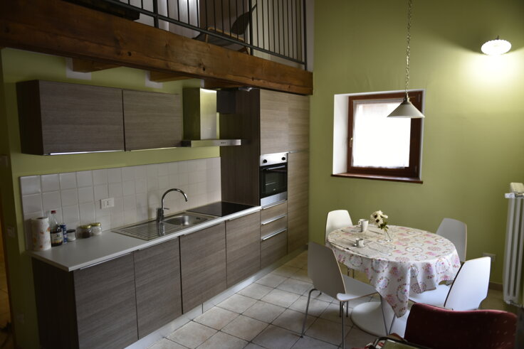 Cucina moderna in un appartamento vacanze con tavolo da pranzo e arredamento confortevole Cucina moderna in un appartamento vacanze con tavolo da pranzo e arredamento confortevole