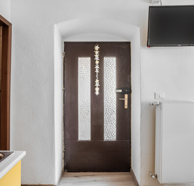 Interno di un appartamento con porta di legno e televisione a muro Interno di un appartamento con porta di legno e televisione a muro