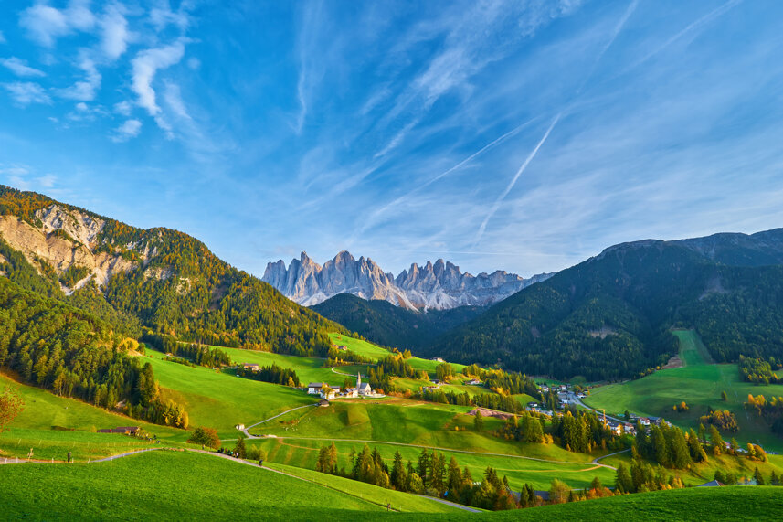 Panorama delle Dolomiti con colline verdi e cielo azzurro