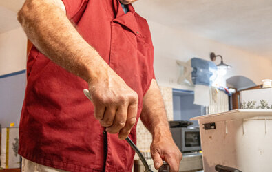 Cuoco in cucina tradizionale prepara piatti tipici