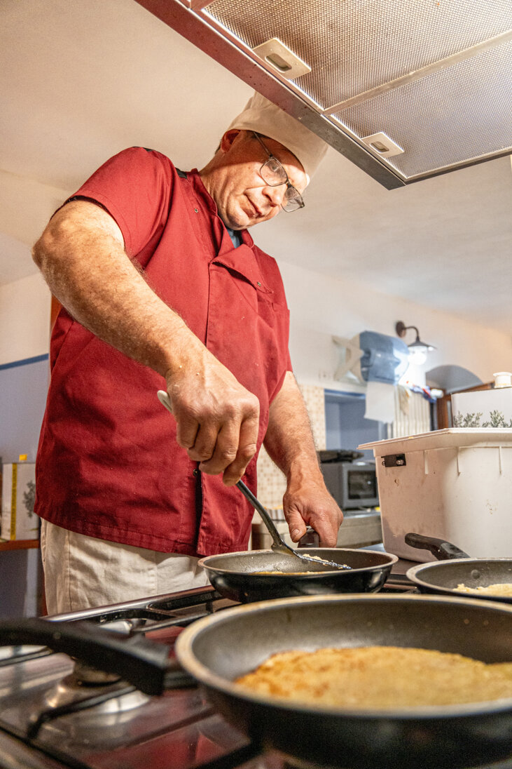 Chef in cucina mentre prepara piatti in un ristorante tradizionale