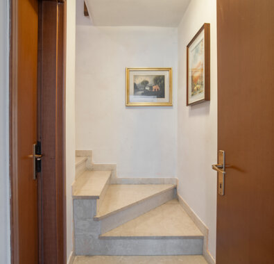 Scala interna luminosa in un appartamento con quadri alle pareti. Scala interna luminosa in un appartamento con quadri alle pareti.