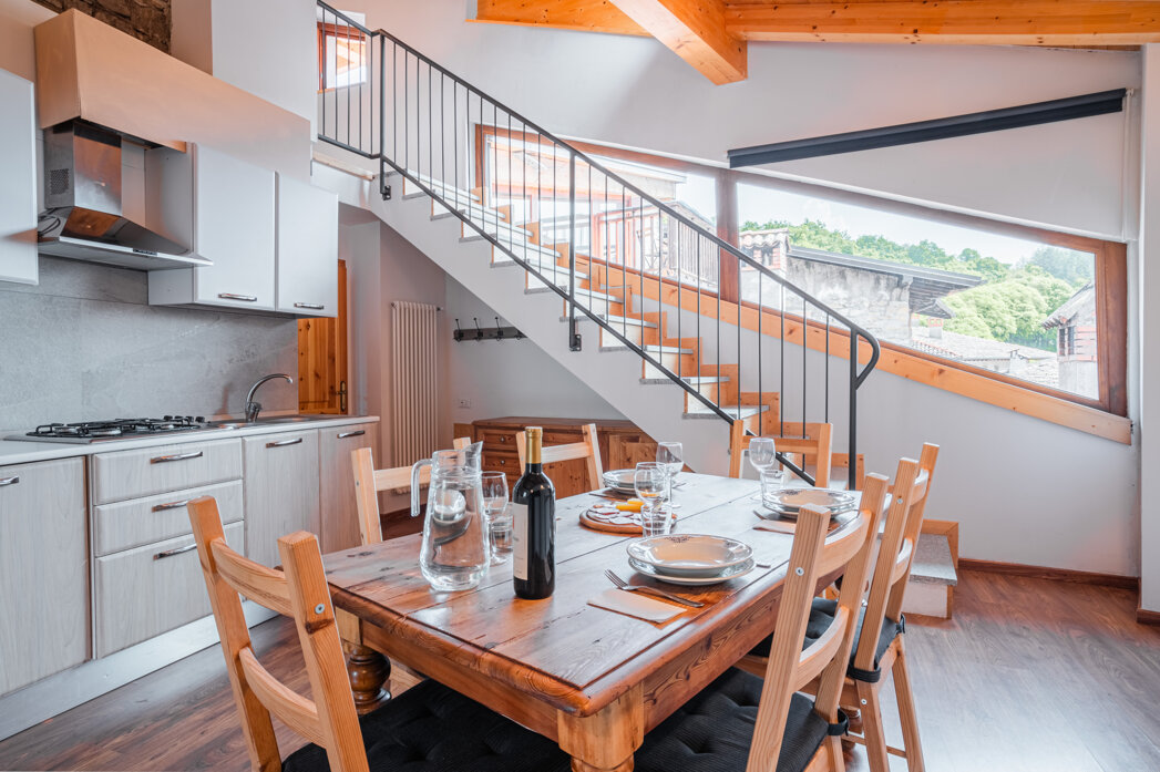 Interno di un appartamento Tenno con cucina moderna e tavolo da pranzo in legno