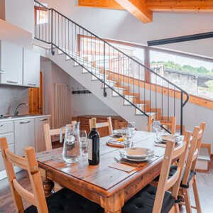 Interno di una cucina moderna con tavolo da pranzo in legno, vista su scala e luci naturali Interno di una cucina moderna con tavolo da pranzo in legno, vista su scala e luci naturali