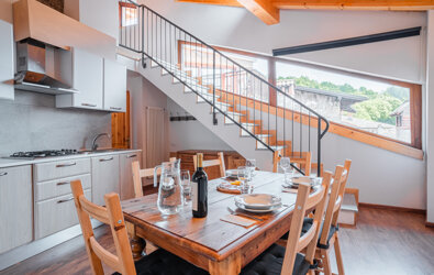 Interno di appartamento a Tenno con tavolo da pranzo e scala moderna