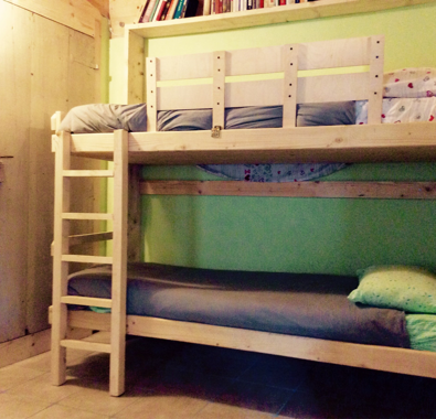 Letto a castello in legno in una camera con pareti verdi Letto a castello in legno in una camera con pareti verdi