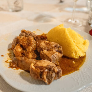 Piatto di polenta e spezzatino su un tavolo apparecchiato Piatto di polenta e spezzatino su un tavolo apparecchiato