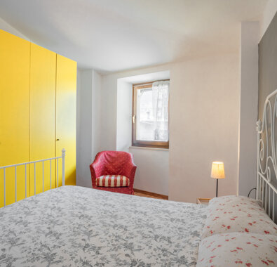 Camera da letto luminosa con armadio giallo e arredi confortevoli Camera da letto luminosa con armadio giallo e arredi confortevoli