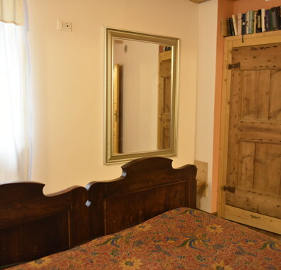 Camera da letto con letto in legno e specchio, atmosfera rustica Camera da letto con letto in legno e specchio, atmosfera rustica