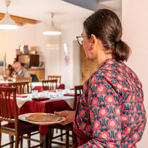 Cameriera serve un piatto in un ristorante accogliente Cameriera serve un piatto in un ristorante accogliente
