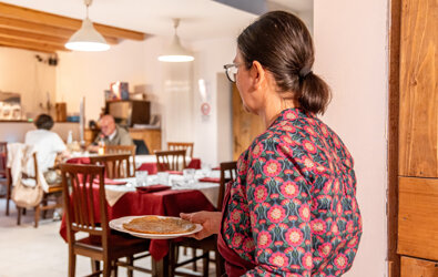 Cameriera che serve piatto in ristorante tradizionale a Tenno