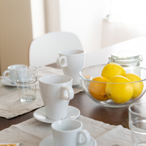 Tavolo apparecchiato con tazze e frutta in una ciotola Tavolo apparecchiato con tazze e frutta in una ciotola