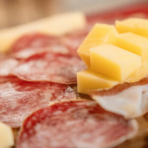 Affettato di salame e cubetti di formaggio su tagliere di legno Affettato di salame e cubetti di formaggio su tagliere di legno