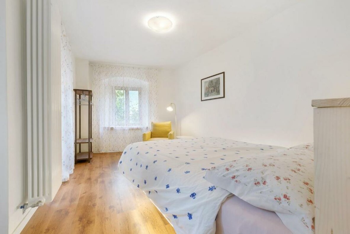 Spacious yellow-themed apartment bedroom with two beds and a red armchair Spacious yellow-themed apartment bedroom with two beds and a red armchair