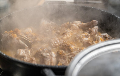 Pollo in pentola durante la cottura con vapore