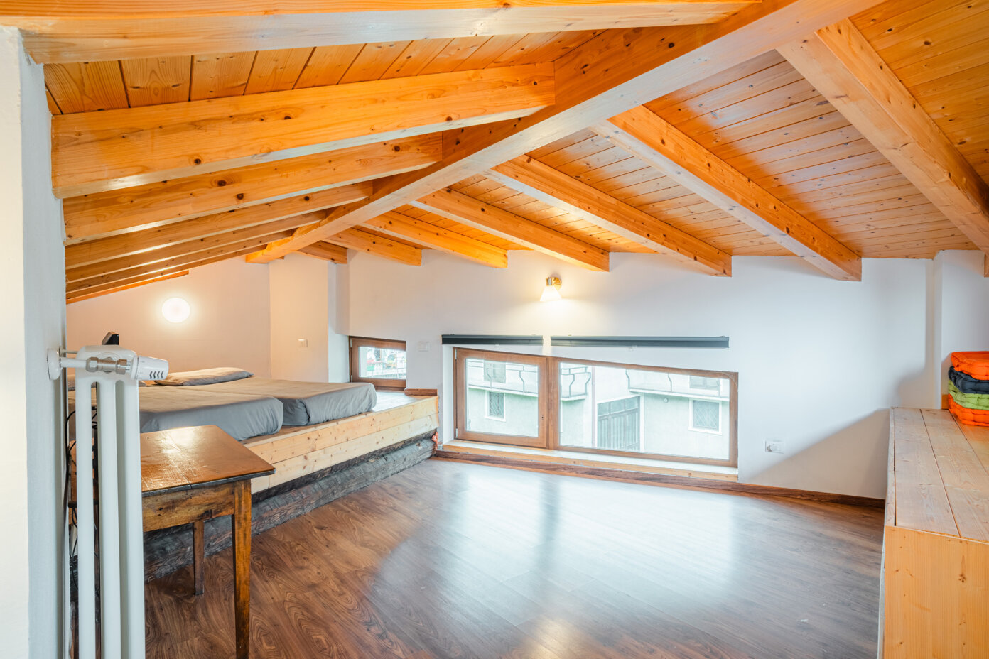 Interno di un appartamento in legno con soffitto a travi a vista in un agriturismo in Trentino