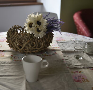 Tavolo apparecchiato con decorazione floreale, tazze e bicchieri Tavolo apparecchiato con decorazione floreale, tazze e bicchieri