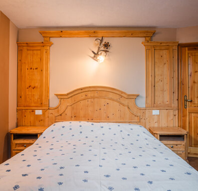 Camera da letto in legno con letto matrimoniale e decorazioni classiche Camera da letto in legno con letto matrimoniale e decorazioni classiche