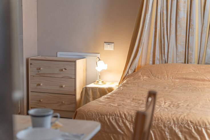 Cozy bedroom in Honey Apartment with lamp and wooden dresser Cozy bedroom in Honey Apartment with lamp and wooden dresser