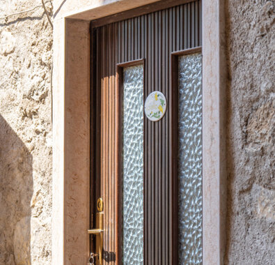 Porta d'ingresso in legno con targhetta gialla e lampada esterna. Porta d'ingresso in legno con targhetta gialla e lampada esterna.