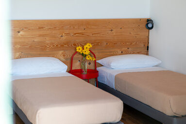 Bright farmhouse bedroom in Carlentini, Sicily with rustic wooden furniture and eco-friendly design.