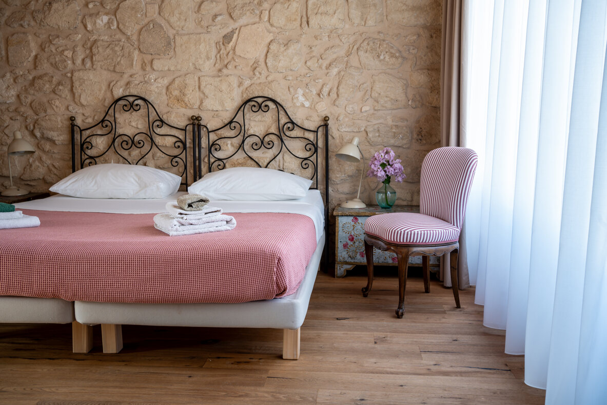 Bright room with twin beds, private bathroom, air conditioning, and stunning views.