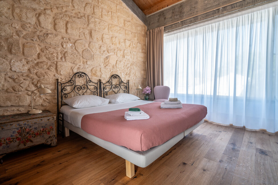 Cozy room with wooden beams, bed, sofa, and decorations