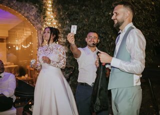 Mago Taz mostra la carta tra gli sposi dopo un numero di magia