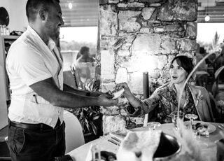 immagine in bianco e nero tratta dall'album degli sposi, gioco di magia tra i tavoli della festa